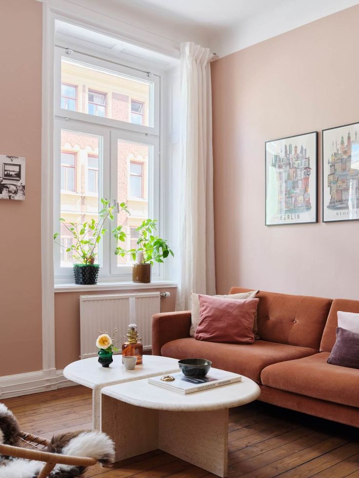 a living room filled with furniture and pink walls