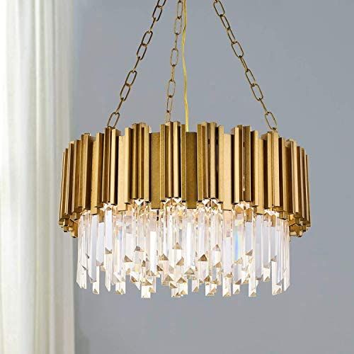 a chandelier hanging from the ceiling in a room with white walls and curtains