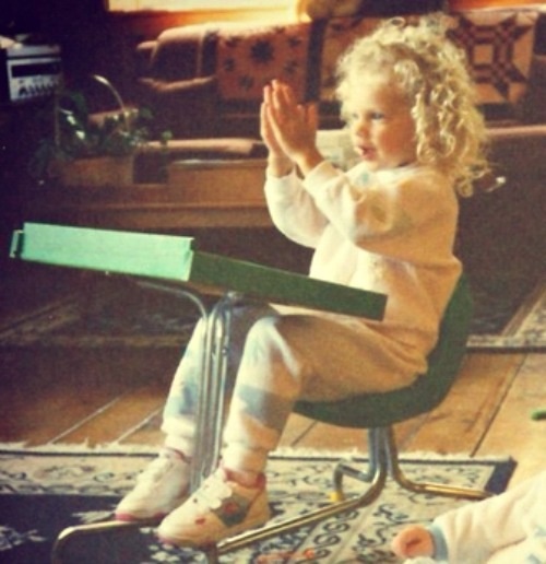 two small children sitting on chairs and playing with their hands in front of the camera