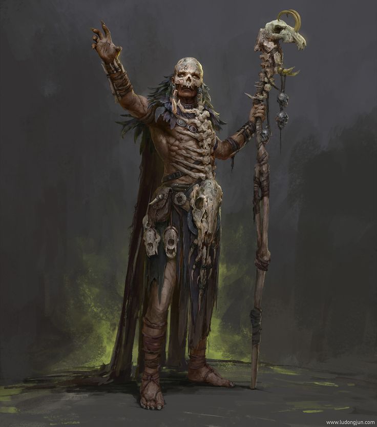 a man dressed as a skeleton holding a sceptacle in one hand and a staff in the other