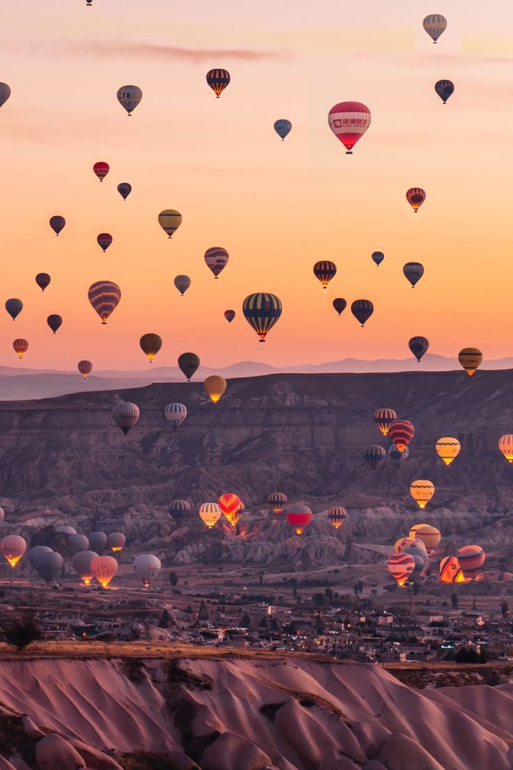 many hot air balloons are flying in the sky