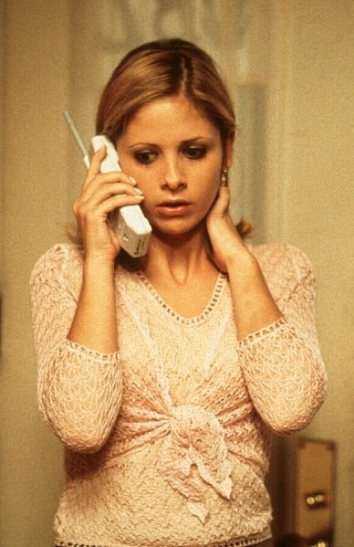 a woman talking on a cell phone while standing in front of a mirror