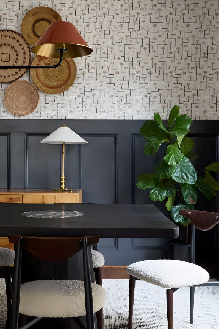 a dining room table with two chairs and a lamp on the wall next to it