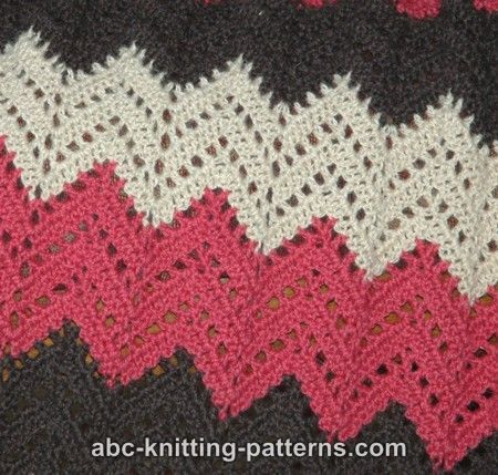 a crocheted blanket with red, white and black stripes on it's edges