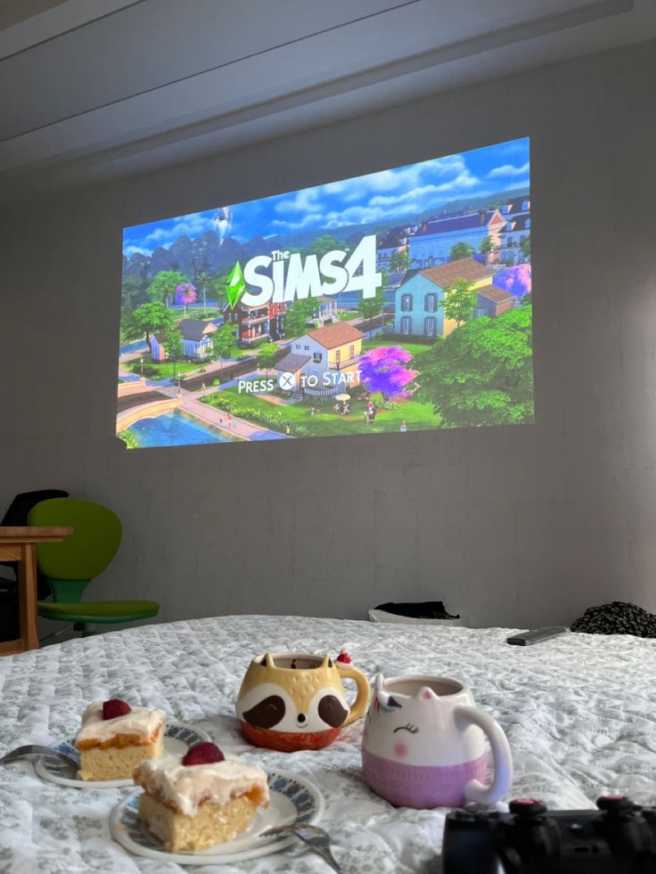 two pieces of cake are sitting on a bed in front of a projector screen