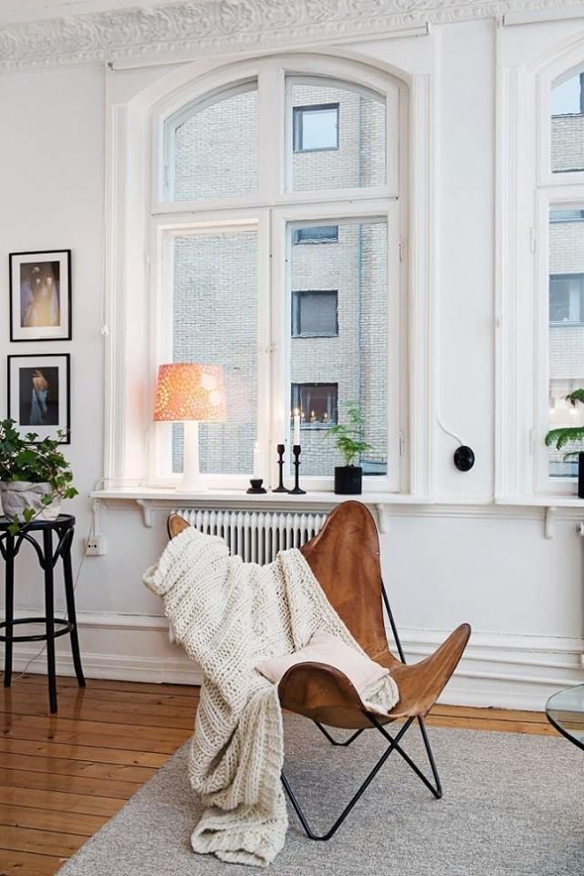 a living room filled with furniture and a large window covered in a knitted blanket