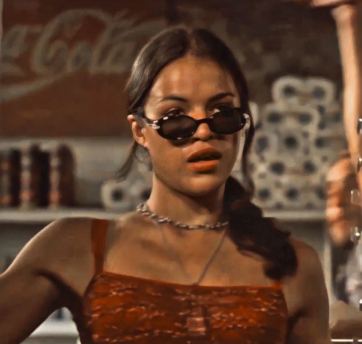 a woman wearing sunglasses standing in front of a counter