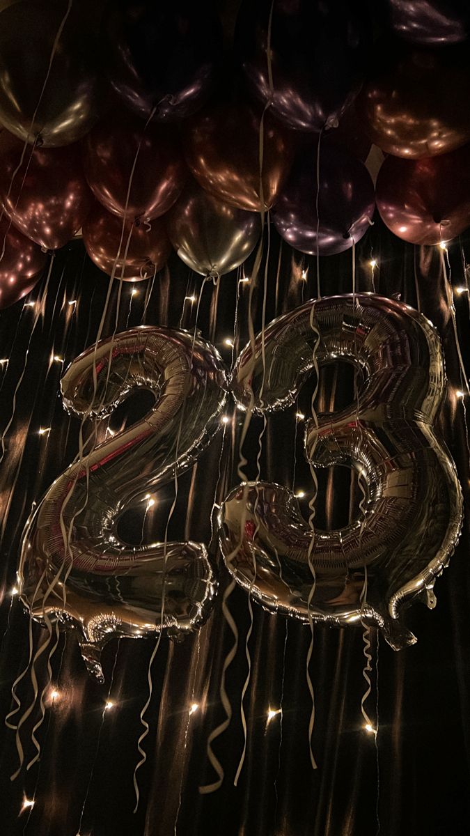 balloons and streamers are hanging from the ceiling in front of the number twenty two