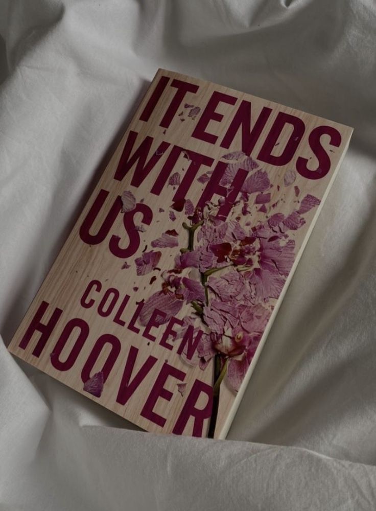 a book that is laying on top of a white sheet with the title it ends with us