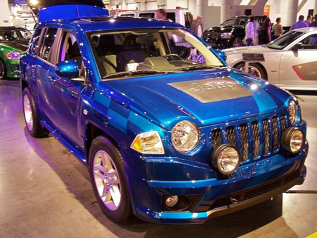 a blue jeep is on display at an auto show