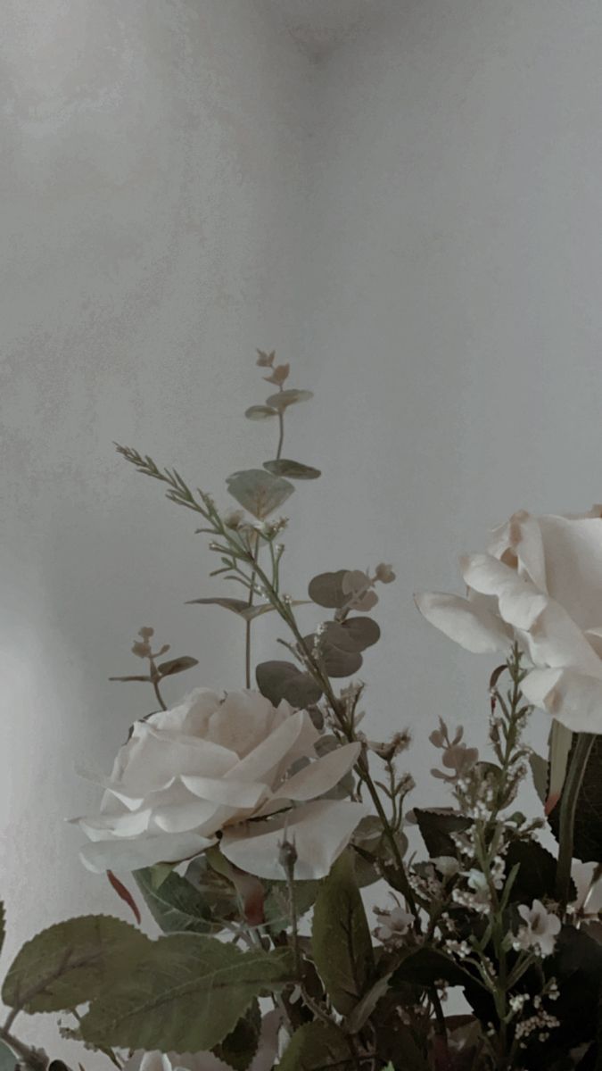some white flowers are in a vase on a table