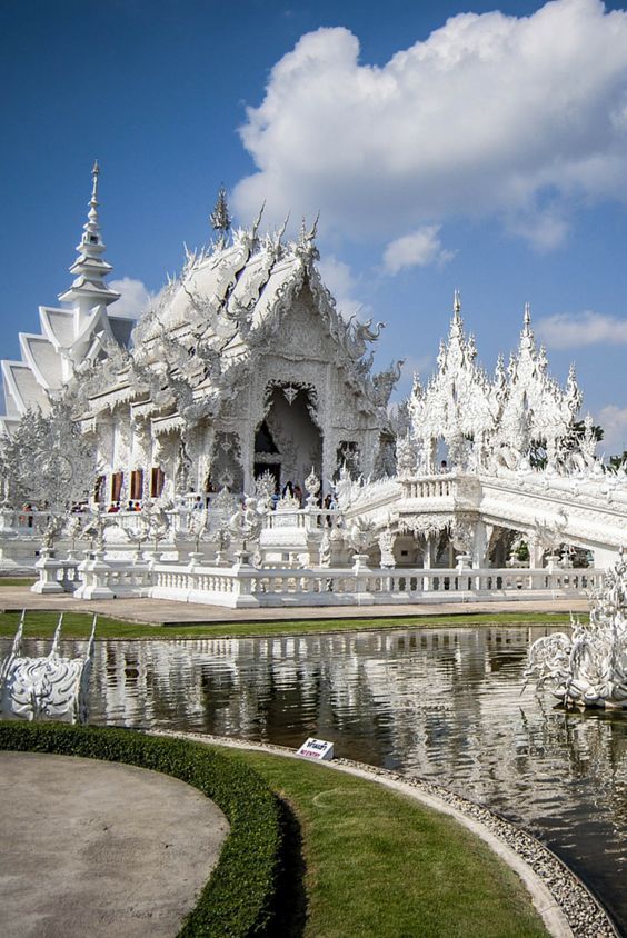 a large white building sitting next to a body of water