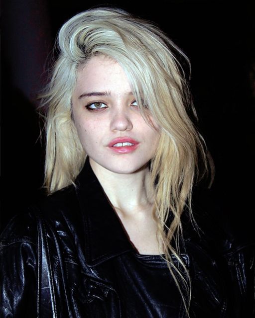 a woman with blonde hair wearing a black leather jacket