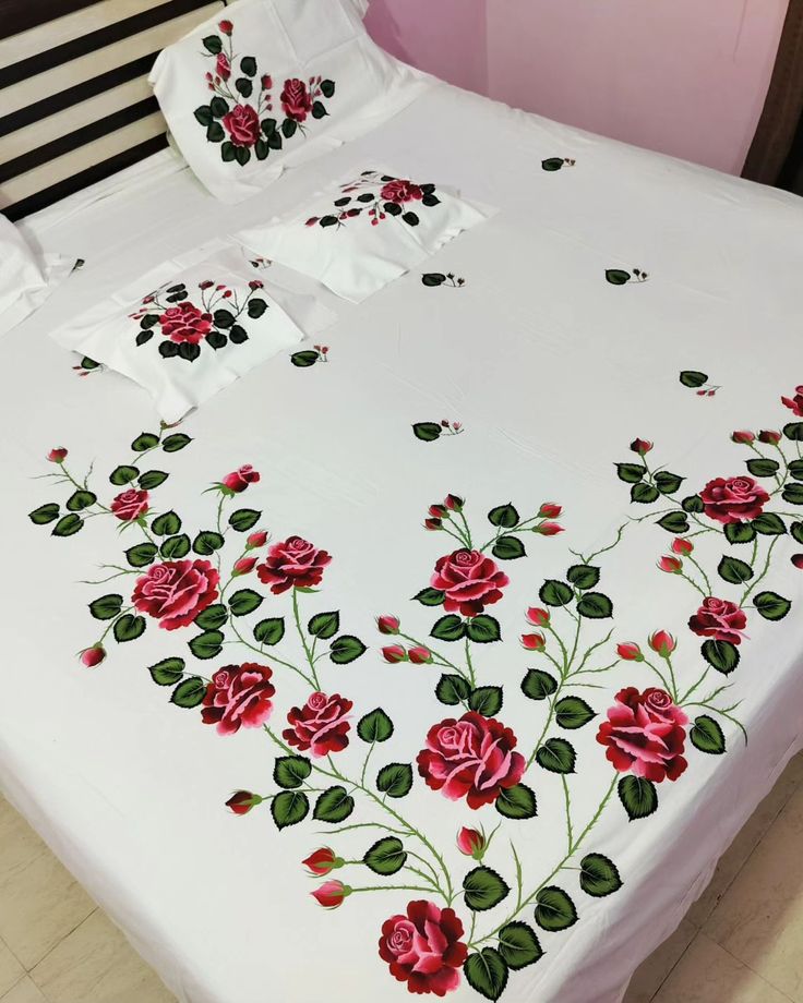 a white bed with red roses on it