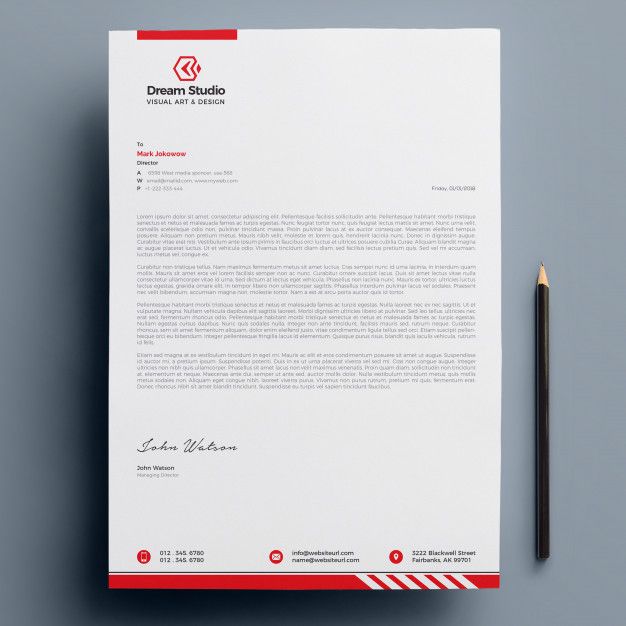 a red and white letterhead with a pencil next to it on a gray surface