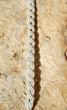 a white beaded bracelet sitting on top of a rock