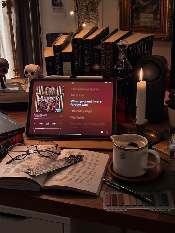 an open laptop computer sitting on top of a wooden desk next to a cup of coffee