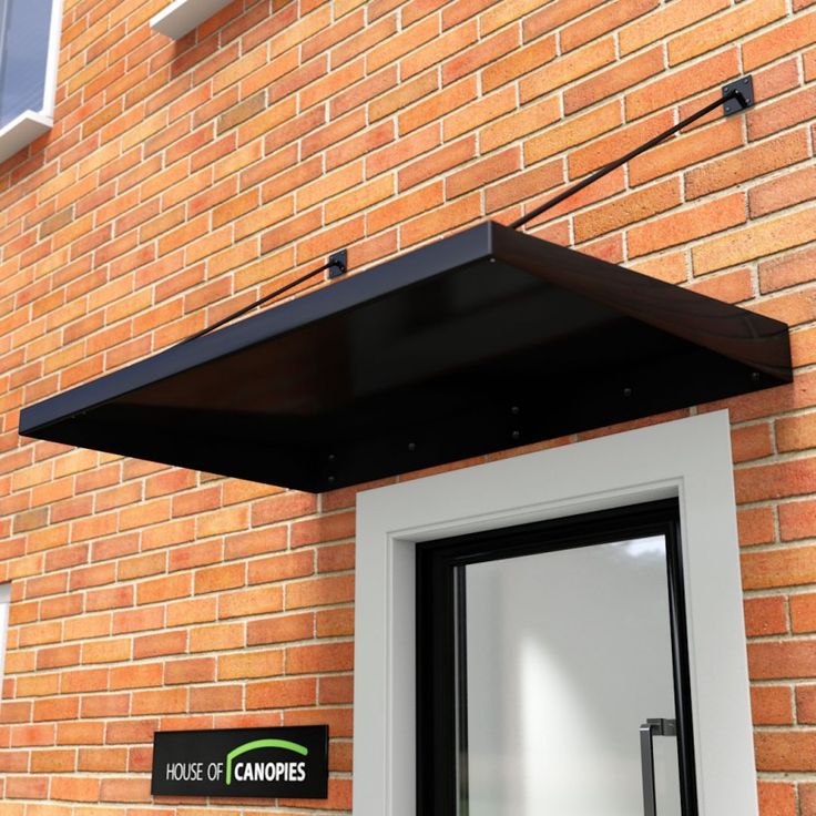 a brick building with a black awning over the door