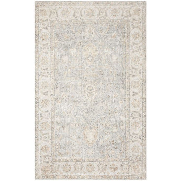 an area rug with light blue and beige colors on the floor, including a large medallion design