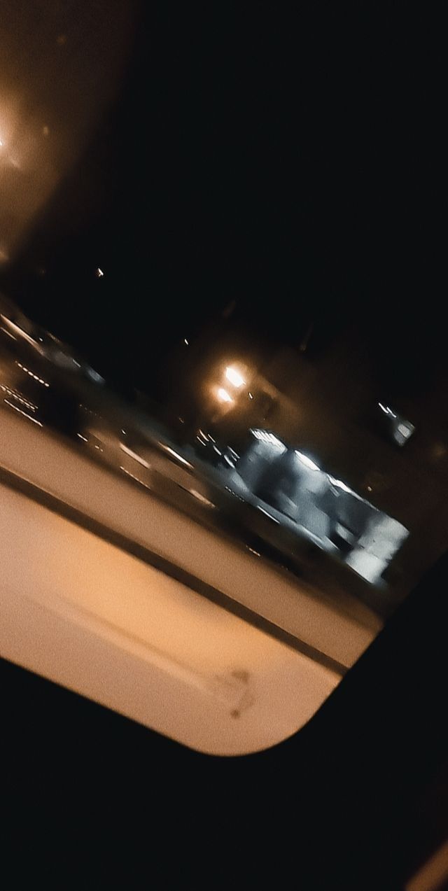 a blurry photo of the inside of a car at night time with street lights