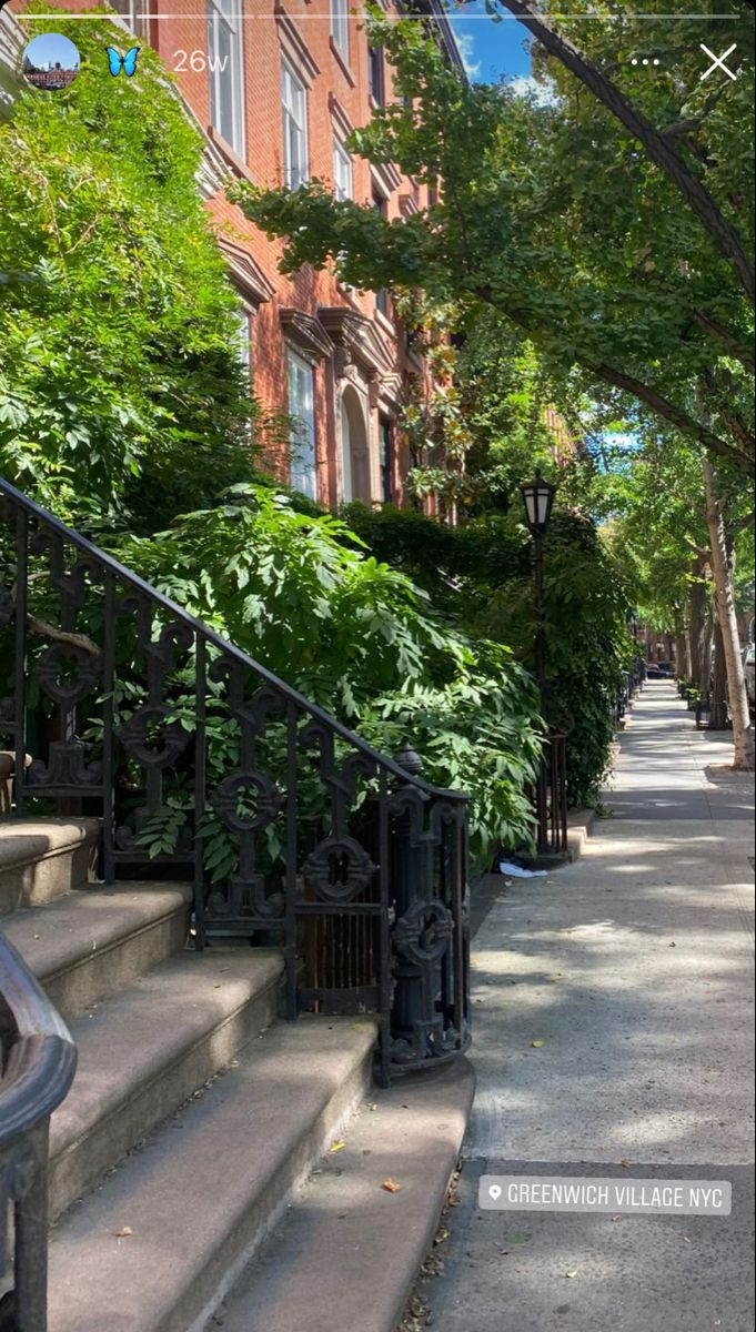 the stairs lead up to an apartment building with iron railings and trees on either side