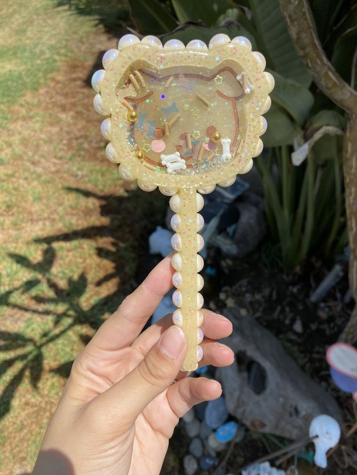 a hand holding an ornate glass object in it's palm tree form with the image of a cat on it