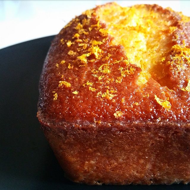 a close up of a piece of cake on a plate with orange zest sprinkles