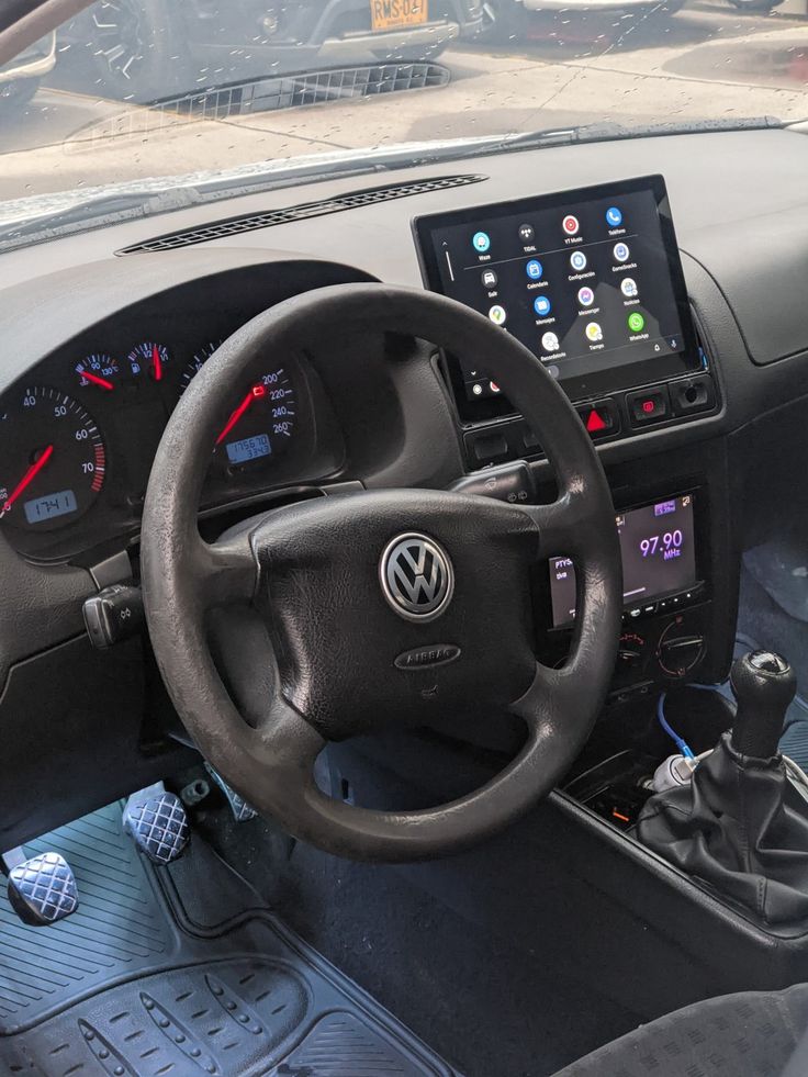 the interior of a car with steering wheel and dashboard