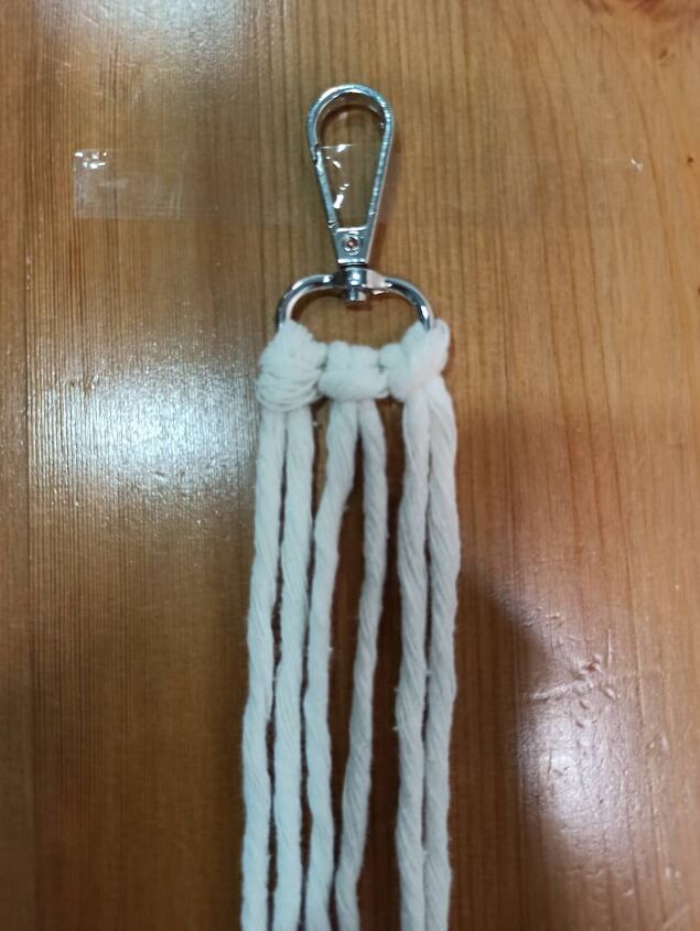 a white piece of rope hanging from a metal hook on top of a wooden table