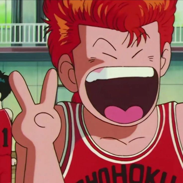 a young man with red hair is making the peace sign while holding his hand up in front of him