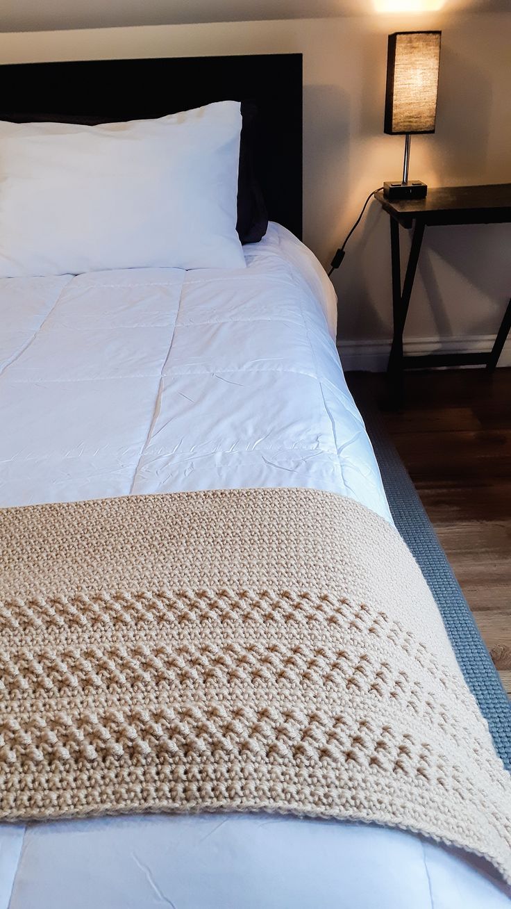 a bed with white sheets and blankets on it