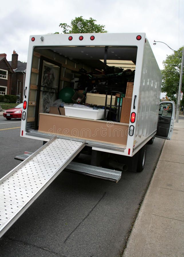 the back end of a moving truck with it's door open and stairs down