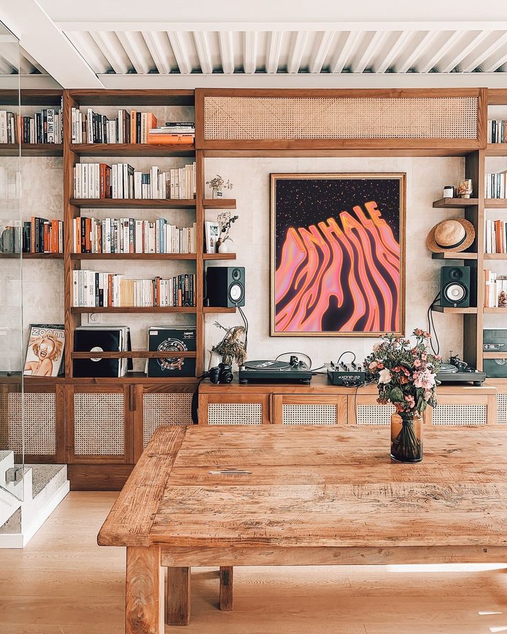 a wooden table sitting in front of a book shelf filled with books