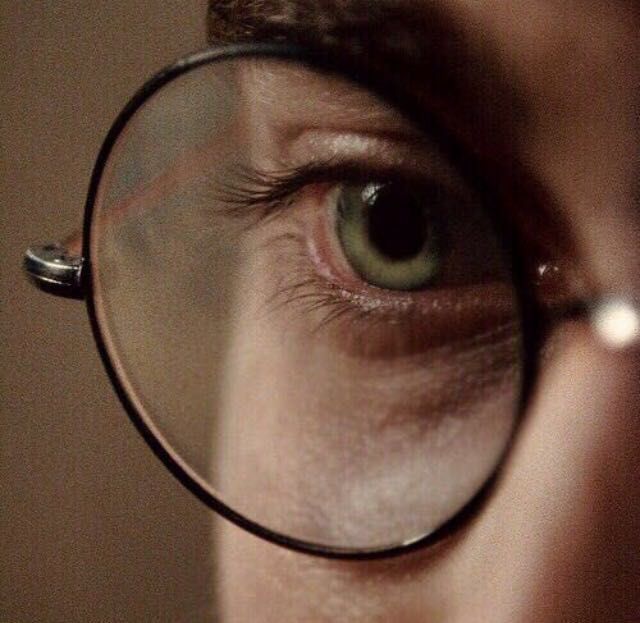 a person looking through a magnifying glass to see something in the distance behind them