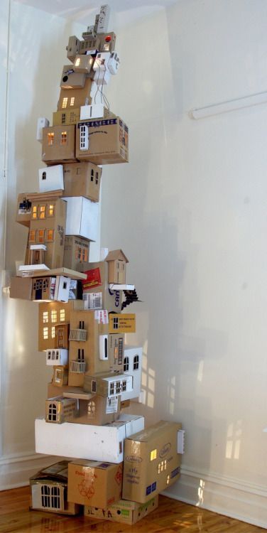 cardboard boxes are stacked on top of each other in the shape of a house,