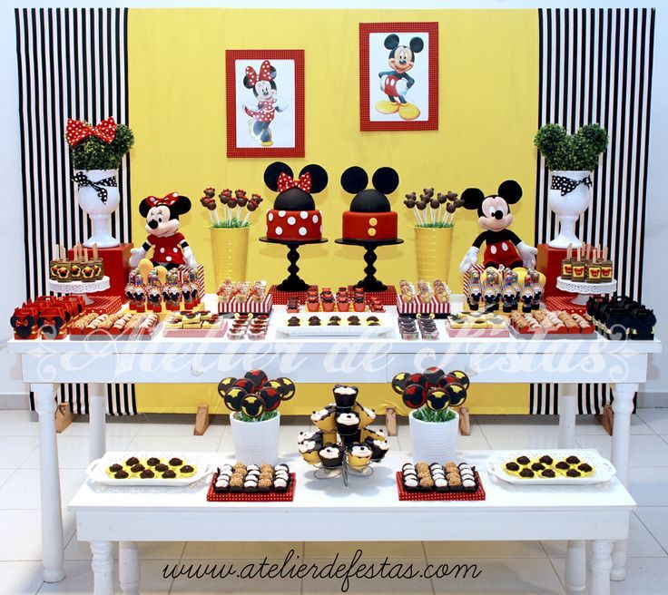 a table with mickey mouse desserts and cupcakes