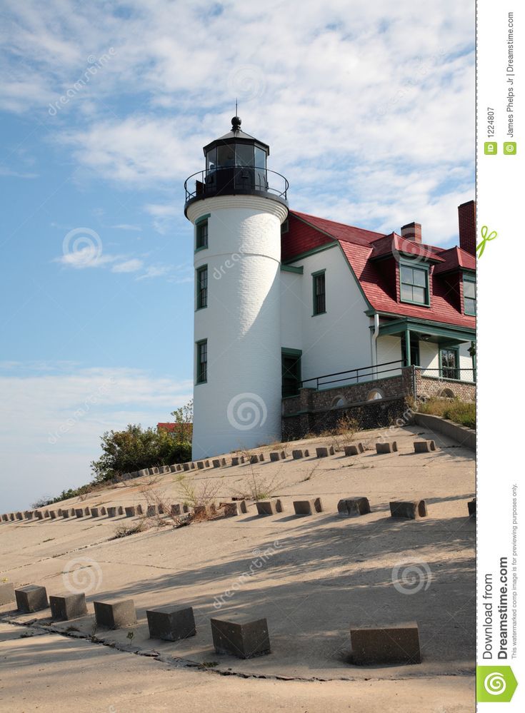 a lighthouse on top of a hill with steps leading up to it and a red roof