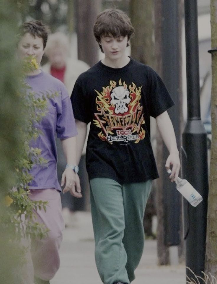 two young men walking down a sidewalk next to each other