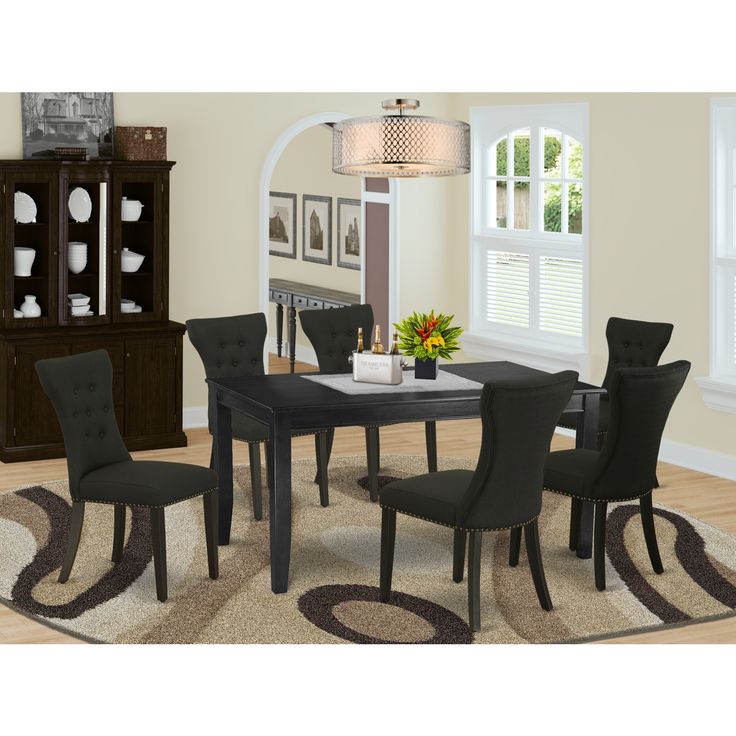 a dinning room table with chairs and a rug in front of the dining room