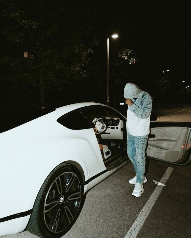 a man standing next to a white sports car