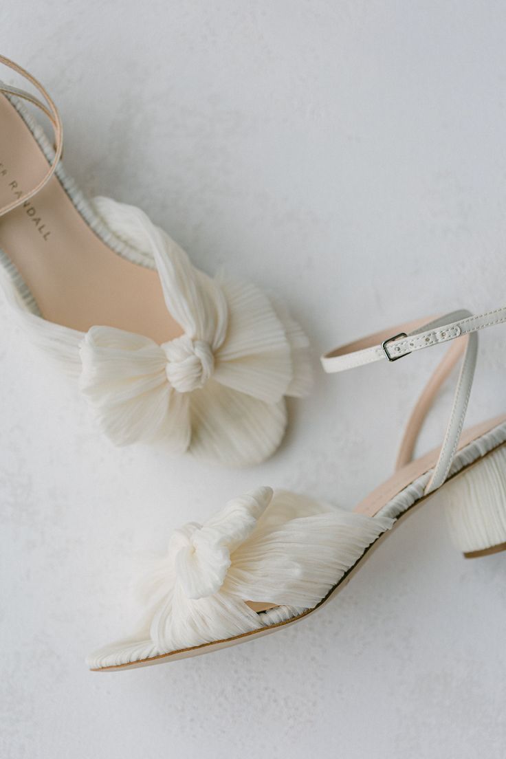 the bride's shoes are all white and have ruffles at the heel