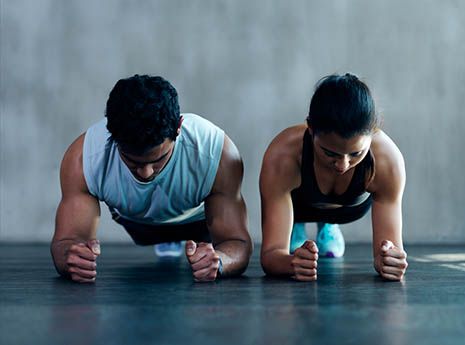 two people are doing push ups on the floor