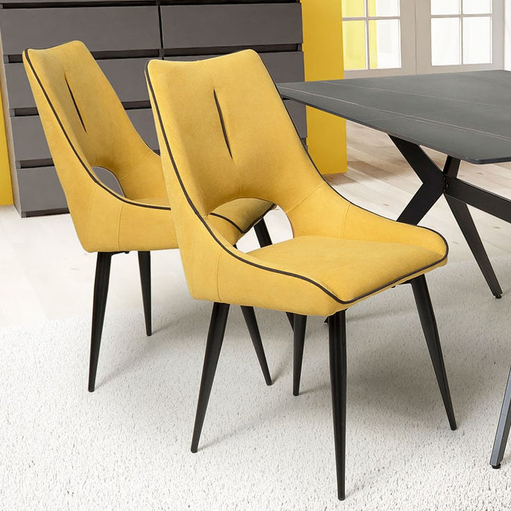 three yellow chairs sitting in front of a black table