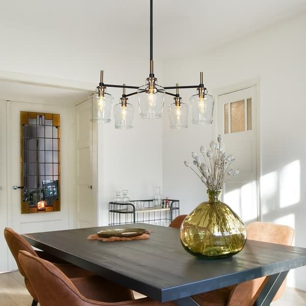 a dining room table with chairs and a vase filled with flowers sitting on top of it