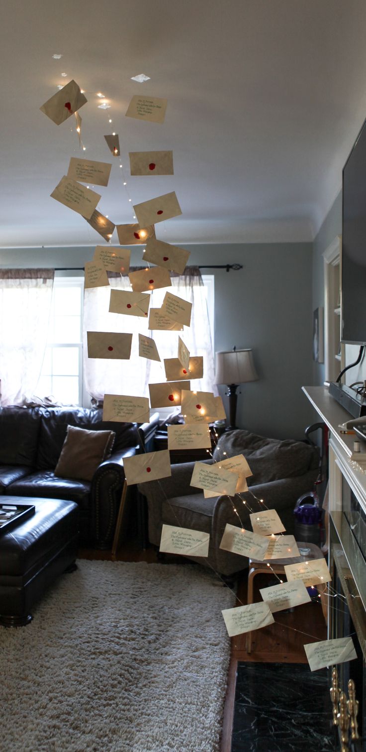 a living room with lots of post it notes stuck to the ceiling and lights hanging from the ceiling