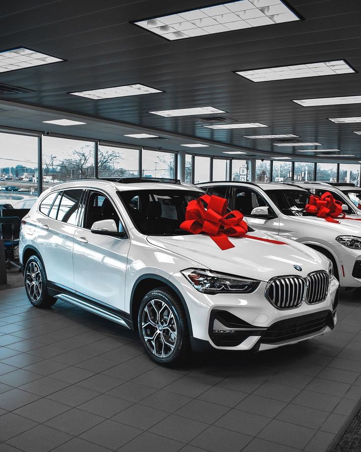 the bmw dealership is decorated with red bows and bow - tied cars for christmas