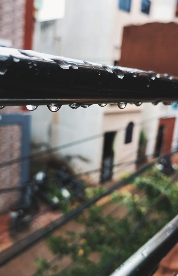 raindrops are hanging from the roof of a building