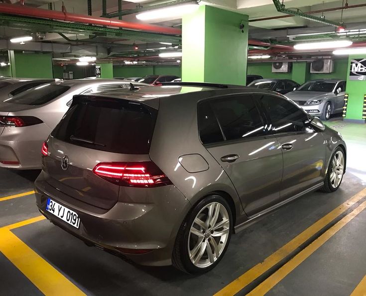 three cars parked in a parking garage with yellow lines