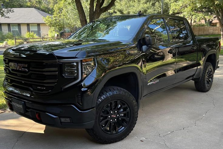 a black truck is parked in the driveway