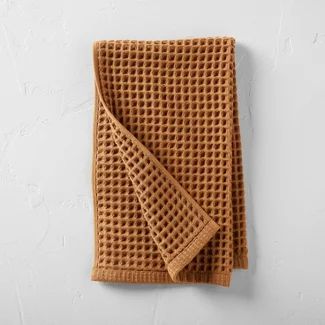 a brown towel folded on top of a white wall